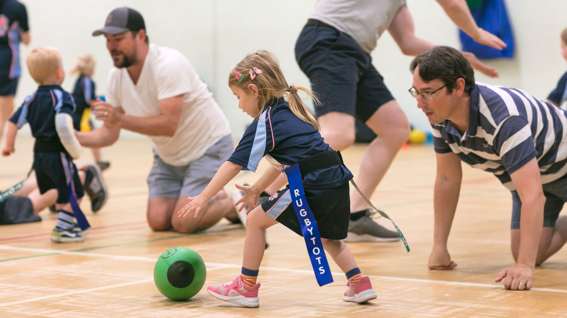 Parents and children taking part in a Rugbytots activity.