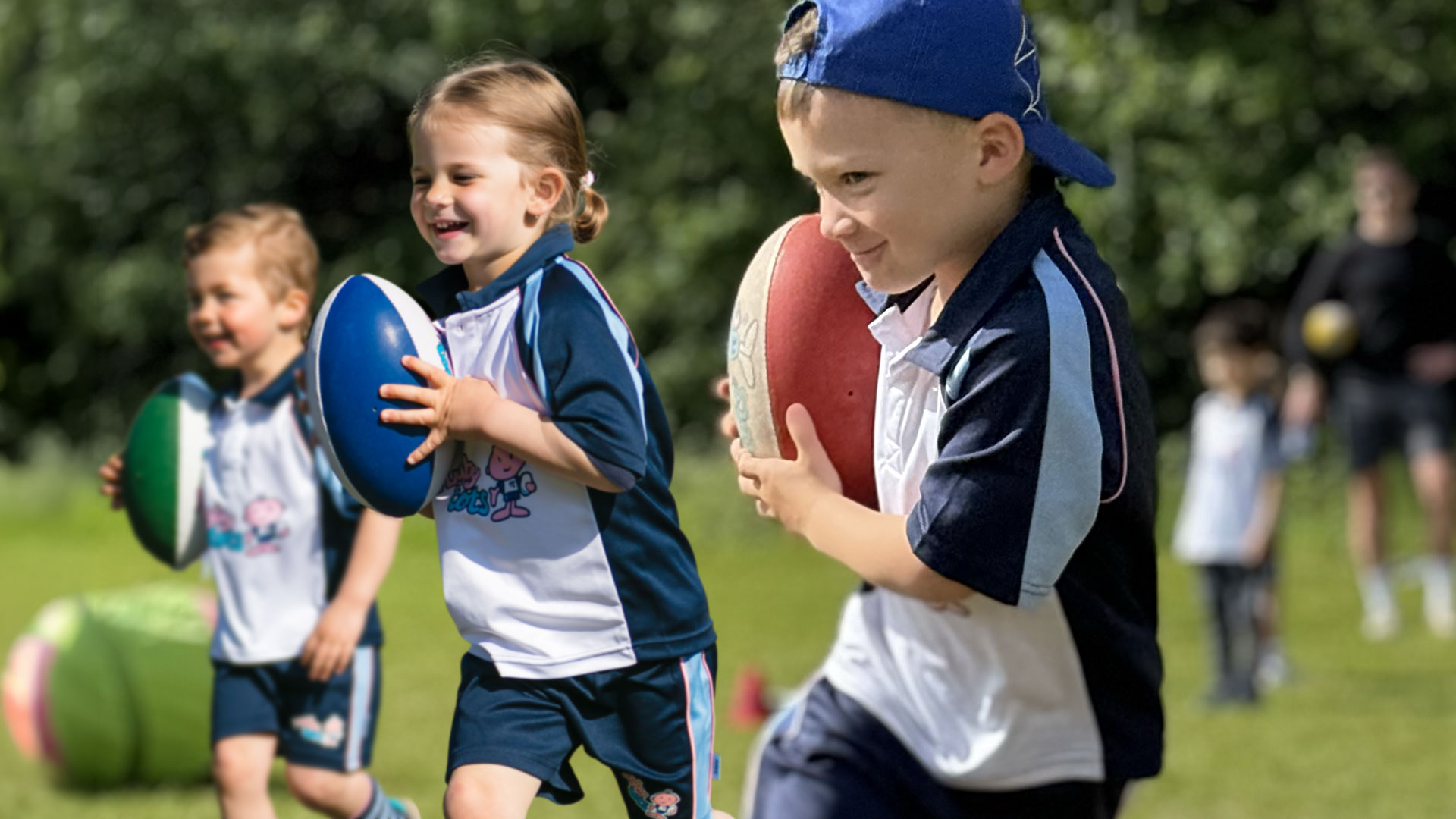 Children having fun running with rugby balls.