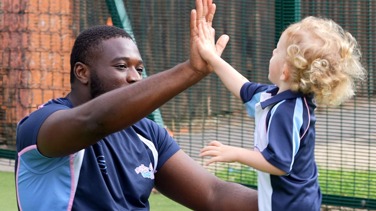 Rugbytots coach giving a child a high-five.