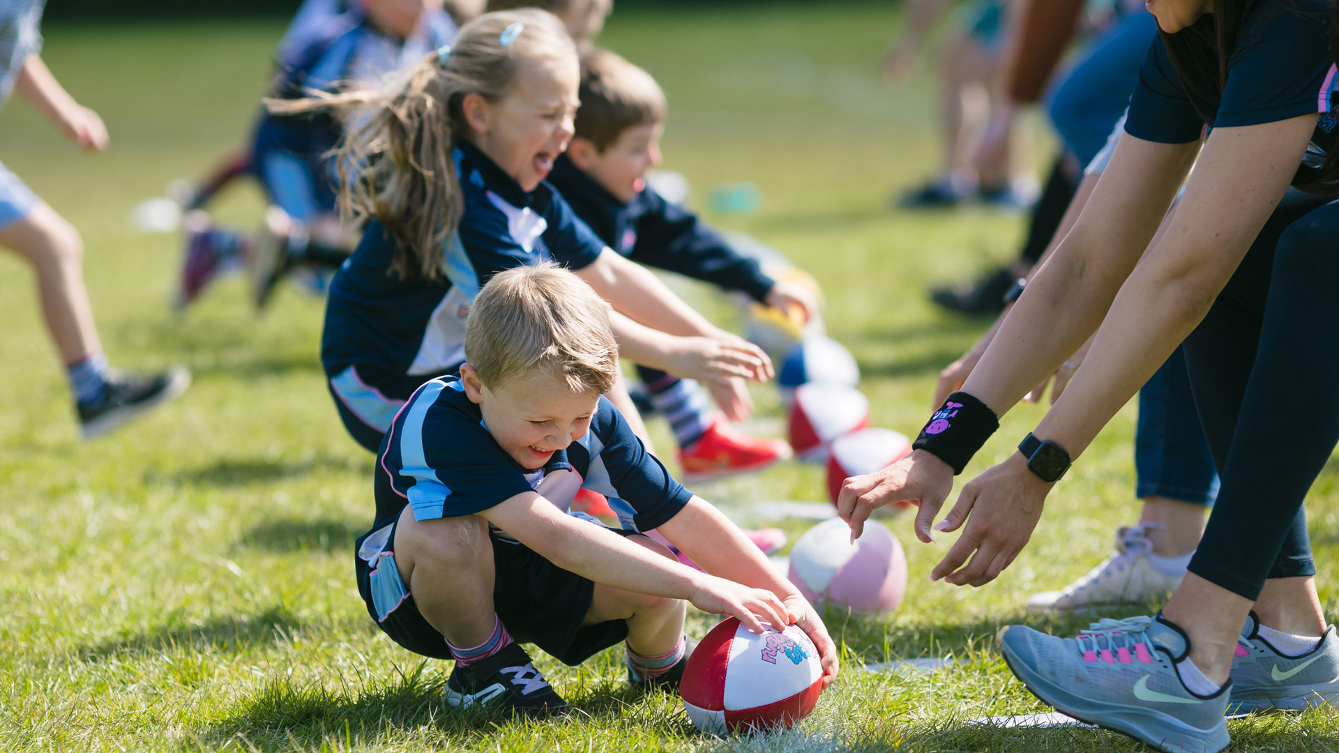 Boys and girls taking part in a game at Rugbytots.